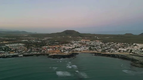 Aerial high level panning view of Corralejo town and harbor at moonset Stock Footage 224038460