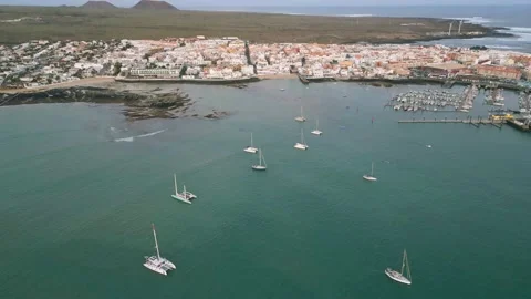 Aerial high level reveal view of Corralejo town early morning with moonset Stock Footage 224038422
