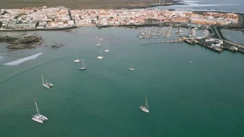 Aerial high level reveal view of Corralejo town early morning with moonset Stock Footage 224038733