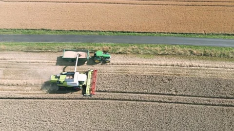 Aerial high level view clip tracking a combine harvester harvesting Stock Footage 205330921