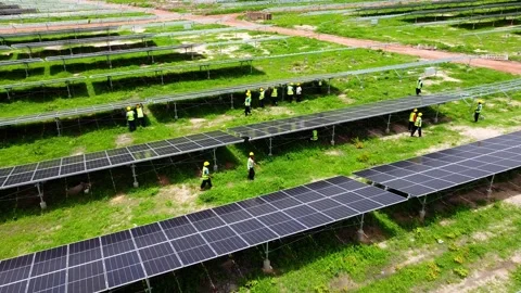 Aerial high rocket pull away view of female technicians working at solar park 스톡 동영상 296783482