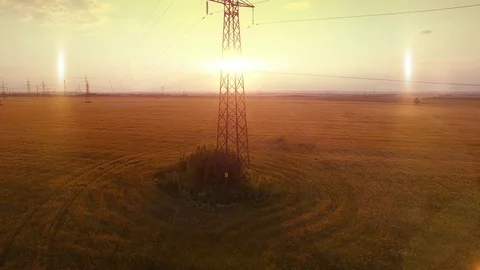 AERIAL High-voltage tower summer warm evening light camera fly up near metal Stock Footage 79853215