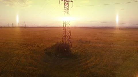 AERIAL High-voltage tower summer warm evening light camera fly up near metal Stock Footage 79853398