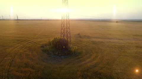 AERIAL High-voltage tower summer warm evening light camera fly up near metal Stock Footage 79854411
