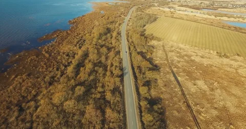 Aerial highway by forests fields water surface in autumn Stock Footage 101461511