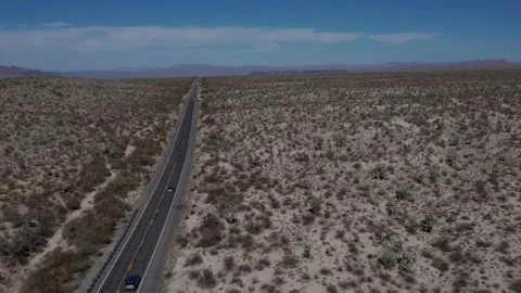 Aerial of a highway through a desolate desert landscape Stock Footage 254356539