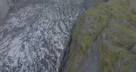 Aerial of a Hillside Split by a Glacier goes from Static to Slow Push In 動画素材 321670317
