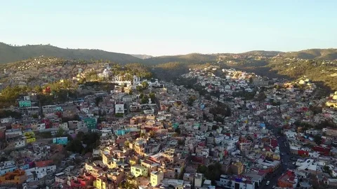 Aerial horizontal pan of a hillside covered in colorful houses at sunset Vídeos de archivo 79709109