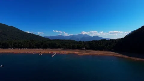 Aerial Horizontal Panoramic Pan of a Crowded Beach Shore with Forest Mounta.. Video stock 339252283