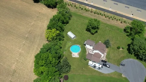 Aerial of house in the suburbs, surrounded by fields and a warehouse Stock Footage 197466971