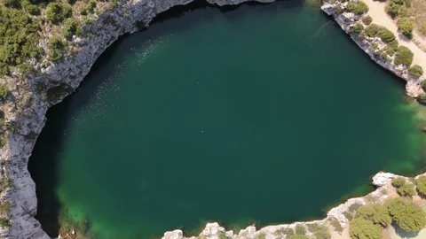 Aerial hover bird's view glittering Dragon Eye Lake surrounded by cliffs Croatia 動画素材 337195113