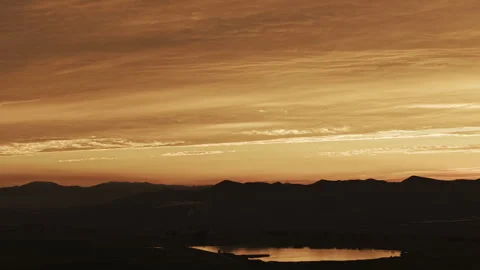 Aerial Hover Mountain Silhouette Lake Sunset Warm Glow 4K HLG Stock Footage 344013847