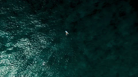 Aerial Hovering Over And Moving Towards A Surfer As She Climbs Onto Her Stock Footage 154567088