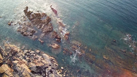 Aerial hovering over cliff and ocean - sequence 2 of 2 - tracking in on the sea. Stock Footage 108548066