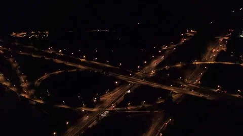 AERIAL: Huge multiple level interchange near suburbs lit up with lights at night Stock Footage 73214638