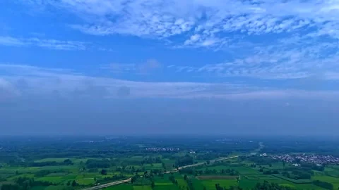 Aerial hyper lapse of clouds and shadows moving across a green farm land 스톡 동영상 347018828