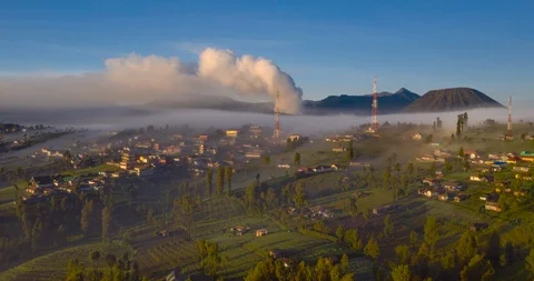 Aerial hyper-lapse of mist flowing in and out of erupting Mount Bromo sunrise Stock Footage 106279666