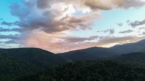 Aerial hyper lapse of sunset clouds moving over mountains Stock Footage 276346354