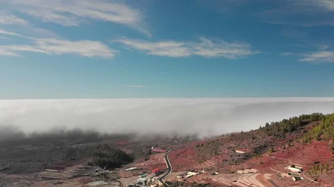 Aerial Hyperlapse Beautiful flight above the clouds over the red volcanic valley Stock Footage 108907268