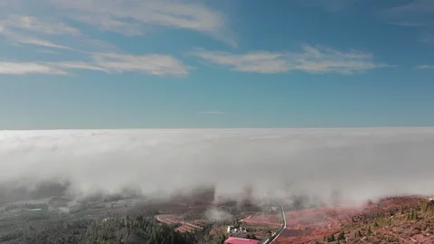 Aerial Hyperlapse Beautiful flight above the clouds over the red volcanic valley Stock Footage 108907654