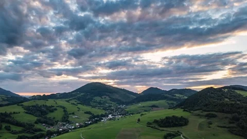 Aerial Hyperlapse of Colorful Clouds Sky over Green Countryside Landscape at Stock Footage 315974079