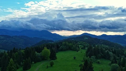 Aerial hyperlapse of dark clouds over a spring forest with a green meadow after Видео 310724187