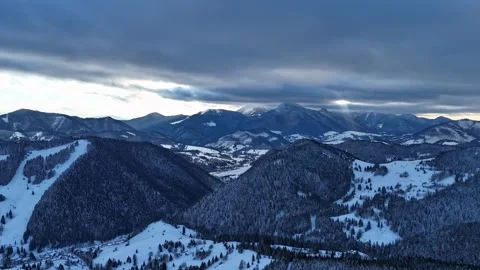 Aerial hyperlapse of dramatic clouds moving over winter mountain peaks and snowy Видео 336394201