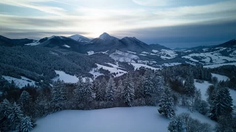 Aerial hyperlapse of dramatic clouds moving over winter mountain peaks and snowy Stockbeeldmateriaal 336394773