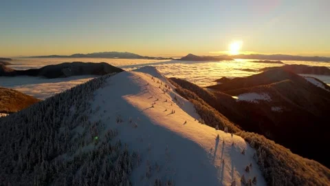 Aerial hyperlapse forward flight over snowy mountain ridge above cloud inversion Видео 322683838