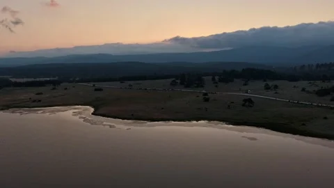 Aerial hyperlapse of heavy clouds rolling over mountains at sunset Stock Footage 340470857