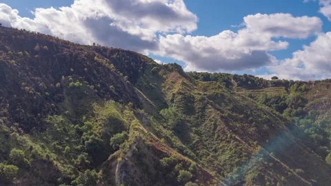 Aerial hyperlapse of mountain forrest with clouds and sun rays 4K Stock Footage 145398922