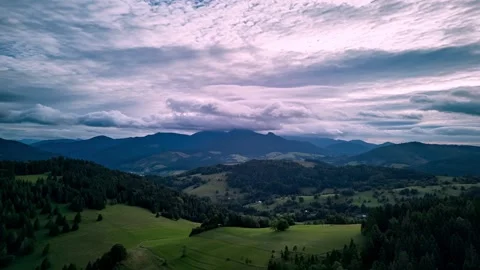 Aerial hyperlapse of mountain landscape with rolling hills and dramatic cloudy Vidéo 319842228