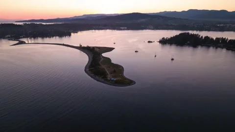Aerial hyperlapse of ocean sunset, peninsula, boats in harbour, peaceful ocean Stock Footage 203390325