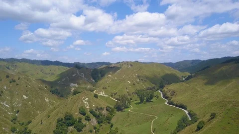 Aerial hyperlapse over green New Zealand farm hills and winding road Vídeo Stock 102480968