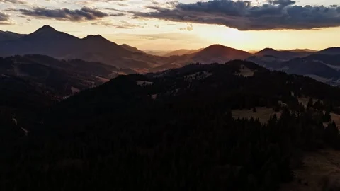 Aerial hyperlapse over hilly forested landscape with dramatic clouds at twilight Video stock 305993925