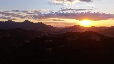 Aerial hyperlapse over hilly forested landscape with dramatic clouds at twilight Stock-Footage 311588364