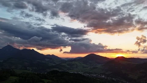 Aerial hyperlapse over hilly forested landscape, dramatic clouds at twilight Stock Footage 317677178