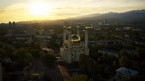 Aerial Hyperlapse over mosque with gold dome at sunrise in mountain city Almaty Video stock 130086070