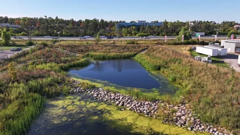 Aerial Hyperlapse Pull Back Over Retention Pond with Highway 400 Stock Footage 317345577