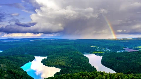 Aerial hyperlapse of a river in a forest and storm clouds with rainbow Stock Footage 159730339