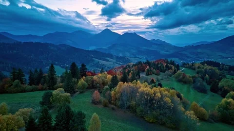 Aerial hyperlapse of rolling hills and autumn forest under dramatic clouds in 動画素材 324494784