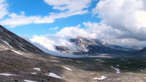 Aerial hyperlapse of a Snow-Covered Mountain Shrouded in Fog Stock Footage 282444088