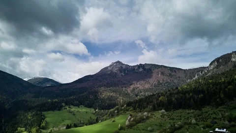 Aerial Hyperlapse spring Alps Mountains,fluffy clouds,green meadows and blooming Video stock 273561146