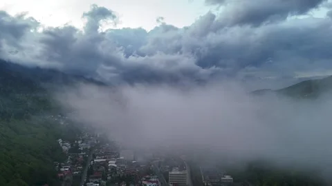 Aerial hyperlapse of storm clouds moving over mountain town in late spring Video stock 274780142