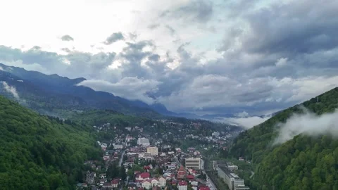 Aerial hyperlapse of storm clouds moving over mountain town in spring season Video stock 274780201