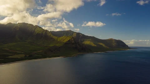 Aerial Hyperlapse of sun rays beaming against a mountain range in Hawaii Stock Footage 136247251