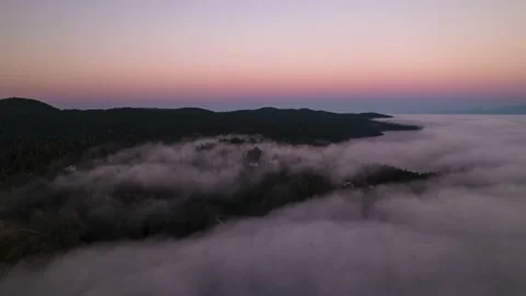 Aerial hyperlapse sunset above clouds, luxury homes on a hill, fog bank, sea of Stock Footage 204103335