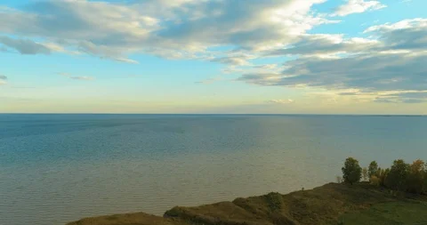 Aerial hyperlapse of sunset and clouds above sea coast. Timelapse drone fly near Stock Footage 115083976
