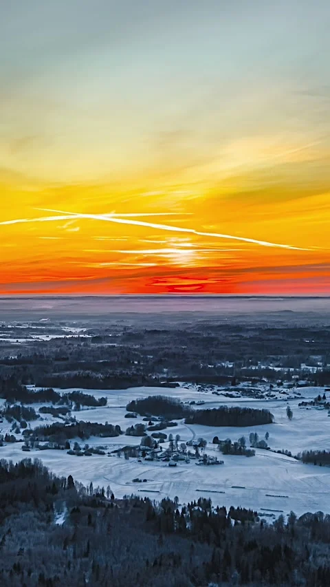 Aerial hyperlapse of sunset on winter evening glow over snow covered forests 스톡 동영상 331061661