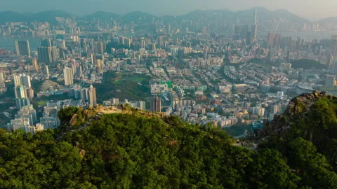 Aerial hyperlapse video of flying over Lion Rock revealing Hong Kong city Stock Footage 252570906